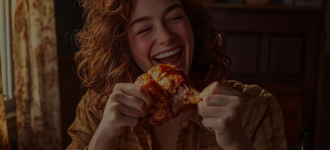 Una mujer comiendo con alegría alitas de pollo crujientes